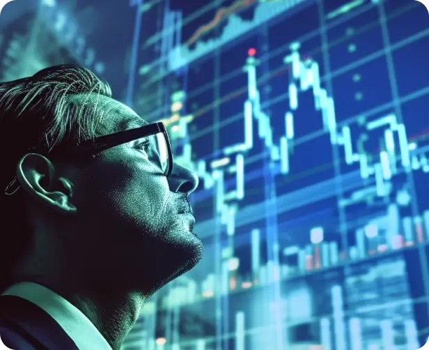 Man with glasses looking at financial charts on a large digital screen