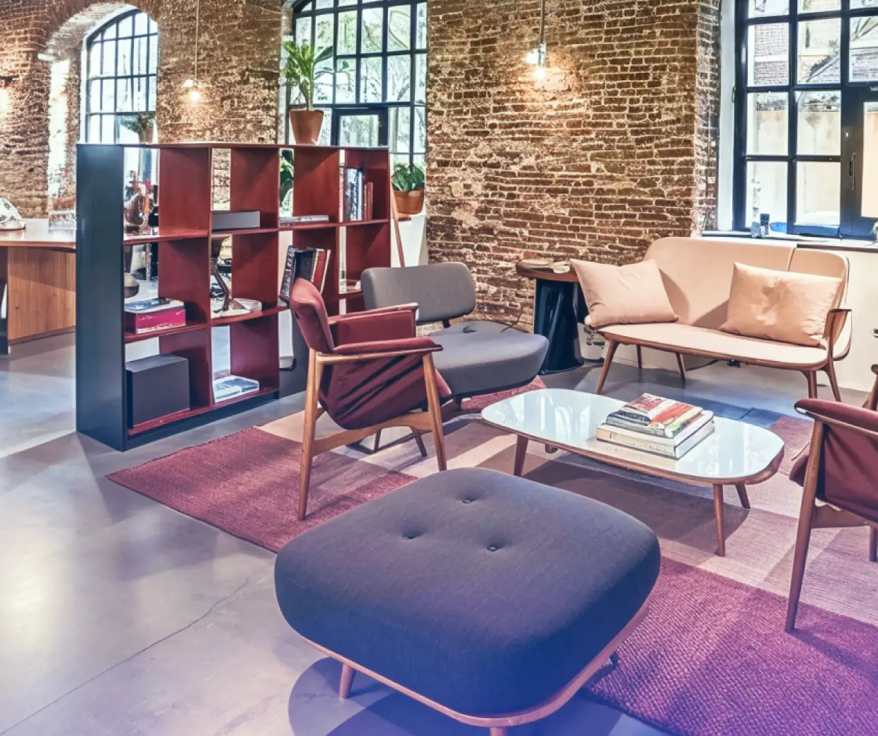 Lounge area of a modern office with brick walls and stylish furniture