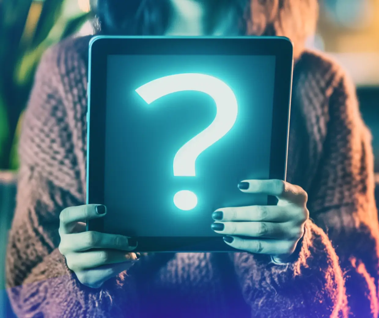Woman holding tablet with glowing question mark on screen